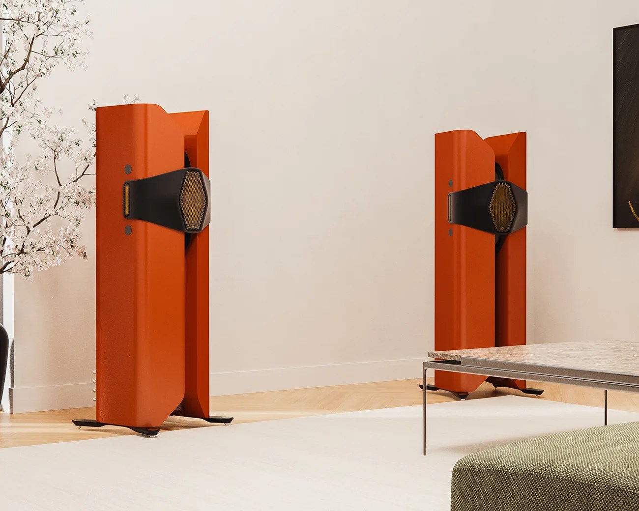 Pair of tall, orange floor-standing speakers with black and gold mesh accents in a modern living room.